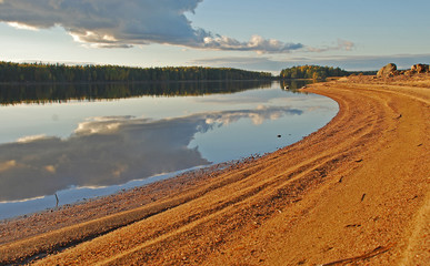 The beach and reflection of clouds on placid lake