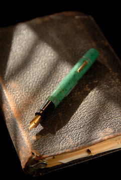 Vintage Fountain Pen And Old Bible Under Dramatic Light