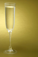 Flute of Champagne on a golden background - vertical