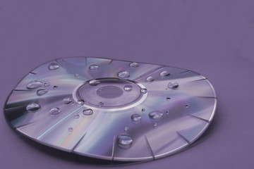 A purple monochrome warped compact disc with water droplets
