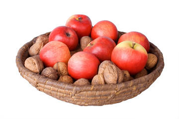 Old wicker basket with walnuts and red apples