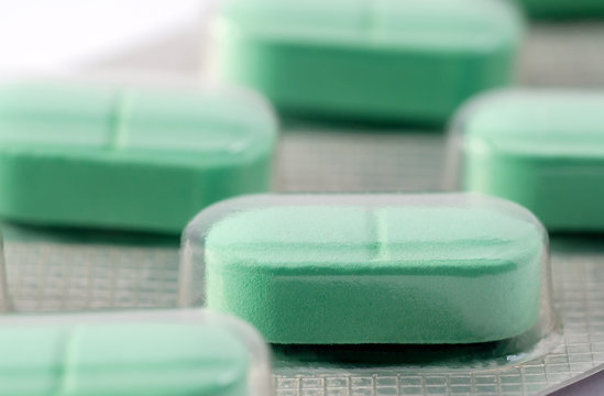 Closeup on pack of  green pills with shallow DOF
