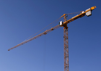 Industrial construction development. Yellow steel crane 