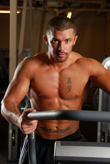 A muscular man walking on a treadmill