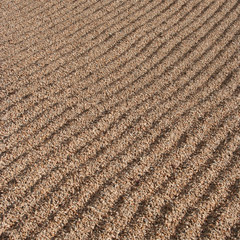 Raked gravel background with parallel ridges