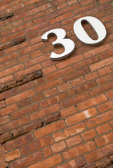 Detail of an urban Brick building with the number 30 on it