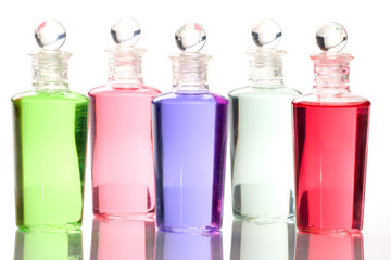 Spa bottles - multi colors - on reflective surface.
