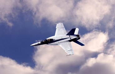 F18 Fighter jet coming down through the clouds