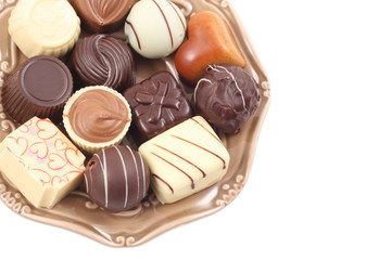 various delicious pralines on plate isolated on white