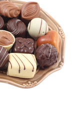 various delicious pralines on plate isolated on white