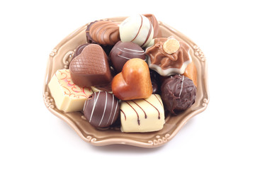 various delicious pralines on plate isolated on white