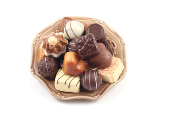 various delicious pralines on plate isolated on white