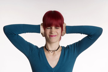 Fototapeta premium a woman with red hair and turned nose holds ear closed