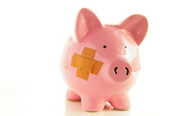 Piggy bank with bandage, metaphor for healthcare costs