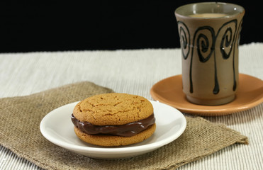 A hot cup of coffee and cookies for dessert
