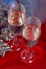 two glasses of champagne with garland on the red