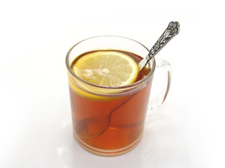 tee and lemon in glass cup, on a white background