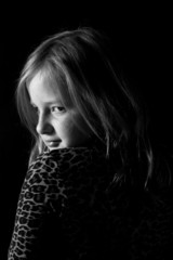 little girl looking over shoulder in black white