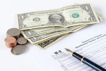 Fototapeta premium W-9 income tax form with pen and american dollars