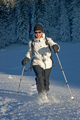 Woman going in the snow with snowshoes.