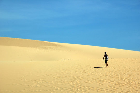 A Man Walking In Sand Dunes