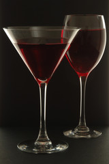 Two Glasses with red liquid on black background