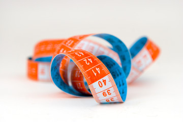 Blue and orange spiral  measuring tape over white