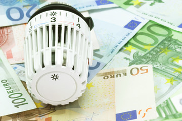 Thermostat mit Banknoten im Hintergrund
