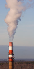 Stand-alone red-white boiler-house chimney smoking