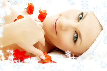 beautiful lady with red flower petals and snowflakes in spa