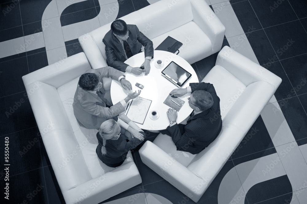 Wall mural business people sitting at the table in the room