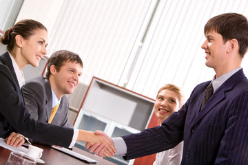 Businessman and woman shaking hands at meeting in the office