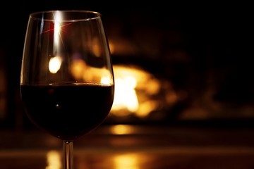 Glass of wine in front of the fireplace 