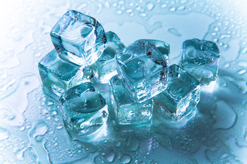 Melting ice cubes on reflective background