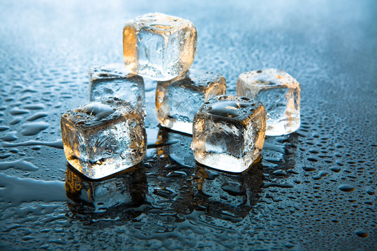Melting ice cubes on reflective background