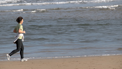 Mujer corriendo por la playa