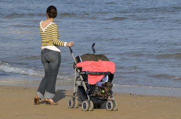 Madre con cochecito de bebe en la playa