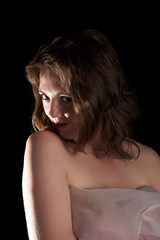 Young smiling freckled girl isolated in the black background
