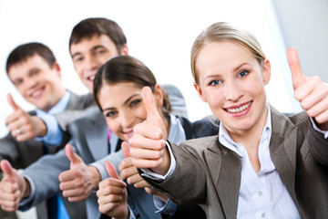 Portrait of business people giving the thumbs-up sign