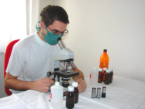 Young doctor with mask and microscope