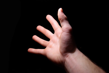 Extended hand for help on a black background