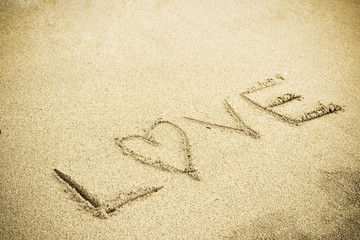A drawing of letter LOVE on the sandy beach