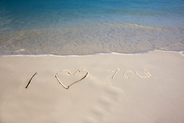 Valentine message written in the sand on a tropical beach