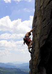 Obraz premium Climber on a vertical rock, high above valley