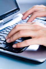 Image of a woman’s hands typing a letter on the laptop