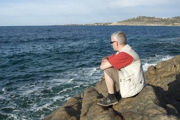homme adulte ragardant la mer