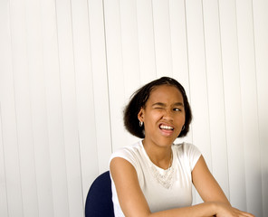 Teenager trying to wink her eye with mouth open