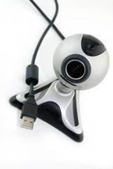 Silver webcam and USB lead isolated against a white background