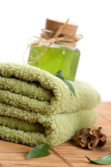 Green towels and liquid soap in glass jar