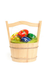 Easter eggs in wooden basket over white background